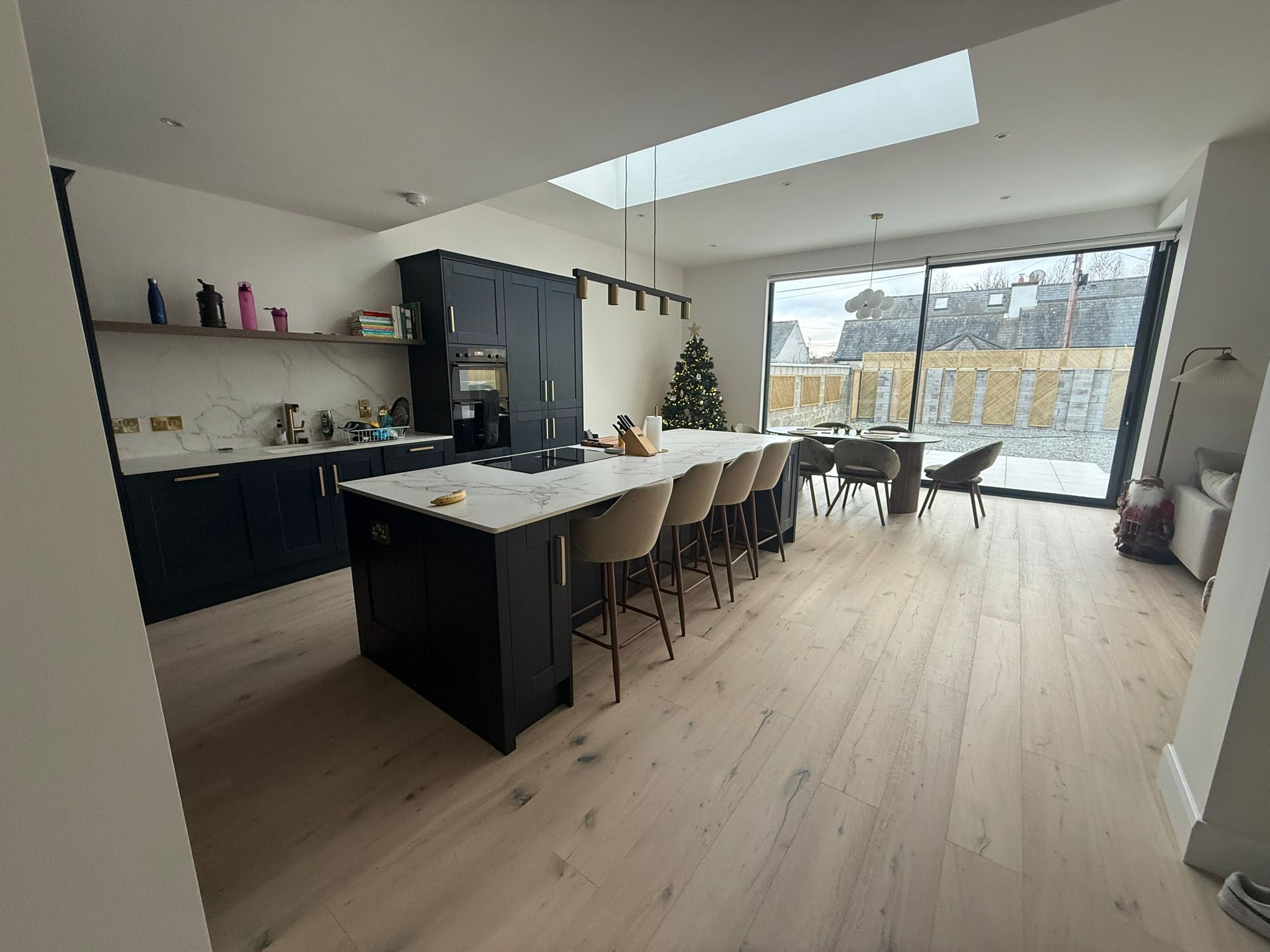Open-plan kitchen dining and living area with skylight and glazed extension wall