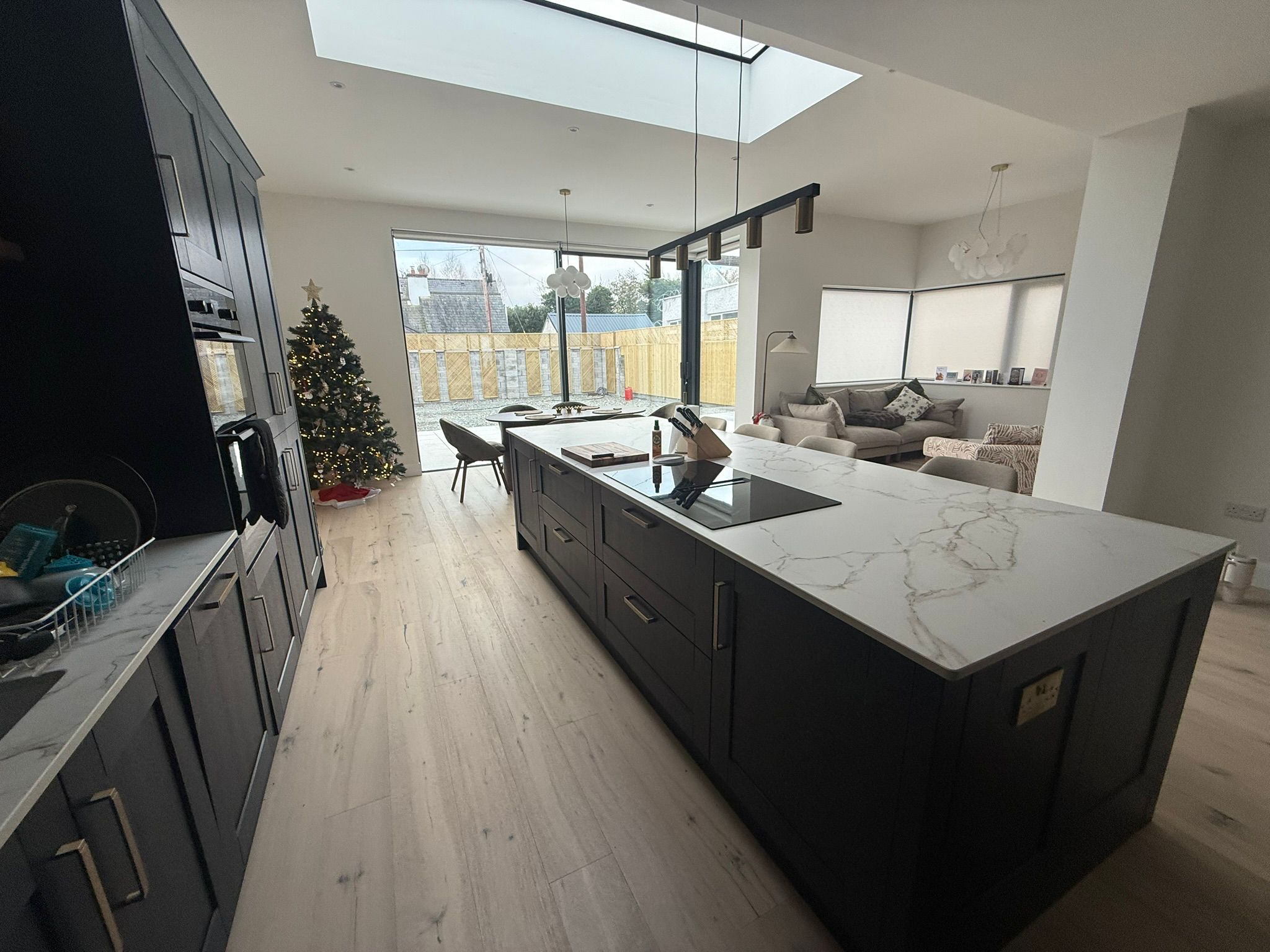 Kitchen island with marble countertop and skylight overlooking open-plan living area