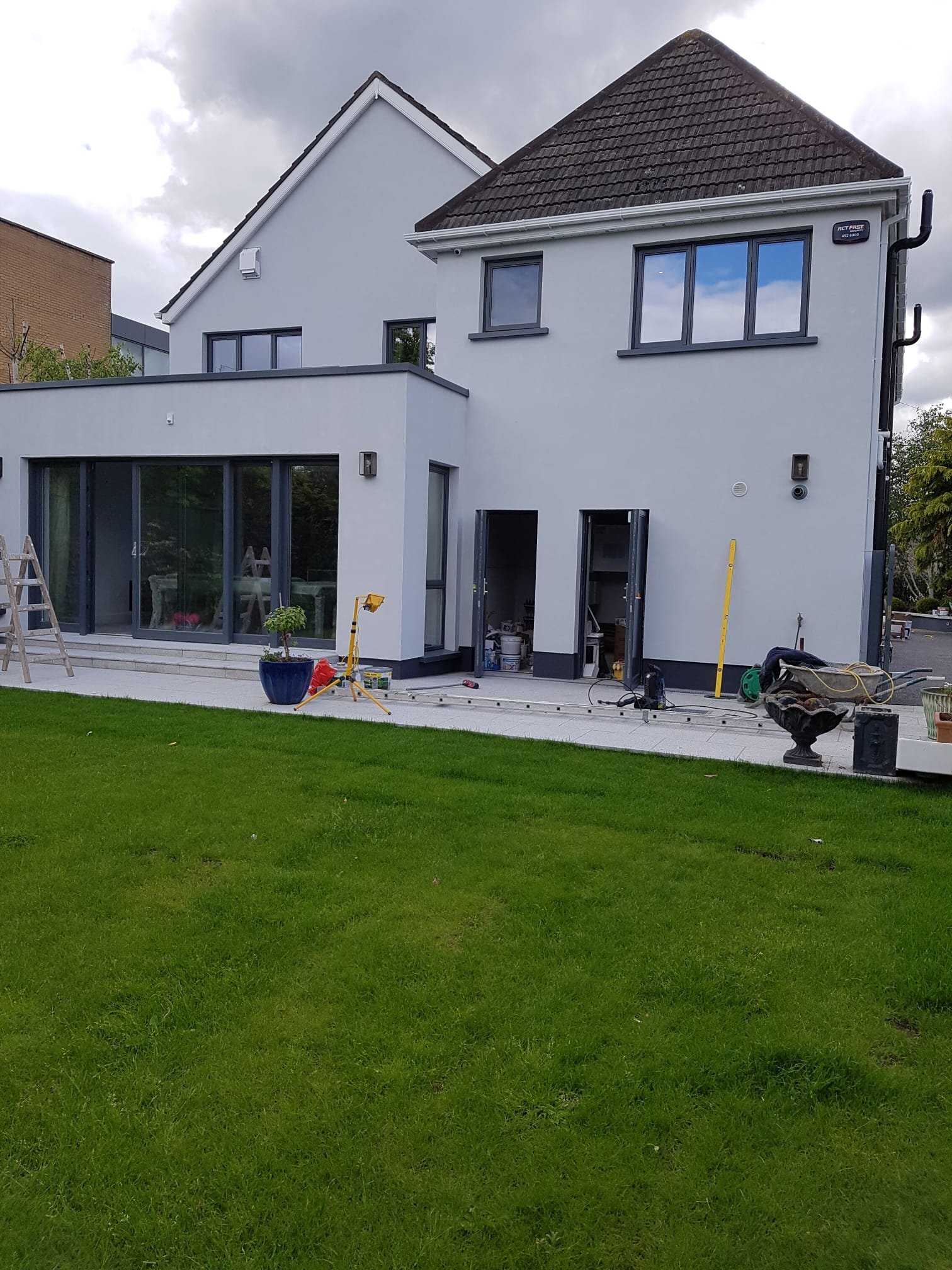 Rear house extension under construction with white render and grey aluminium windows